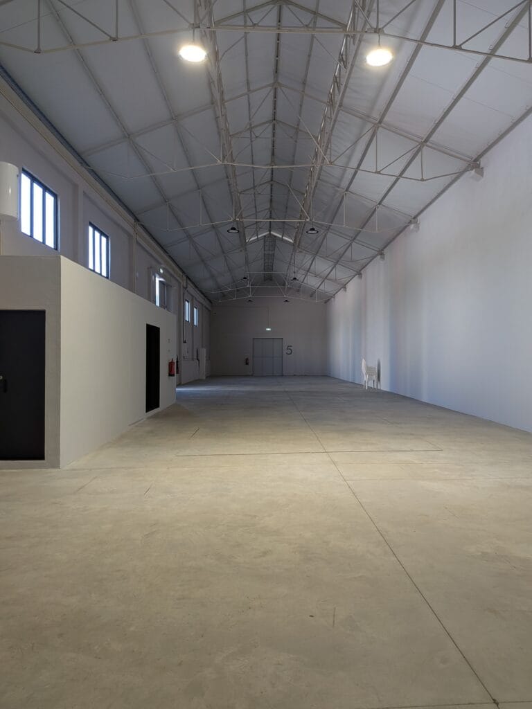 Interior do armazém da Show Reel, espaço amplo e desimpedido com 5,6 m de pé-direito, em Lisboa